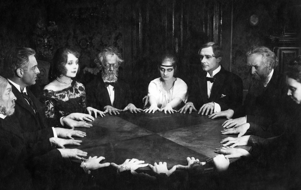 A group of people at a Victorian Era seance.